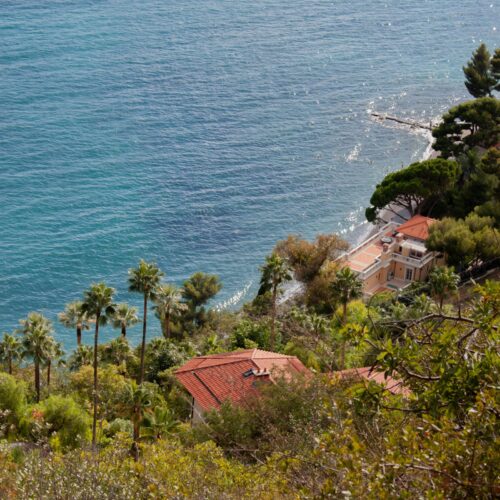 Villa mediterránea con vistas al mar entre vegetación de pinos