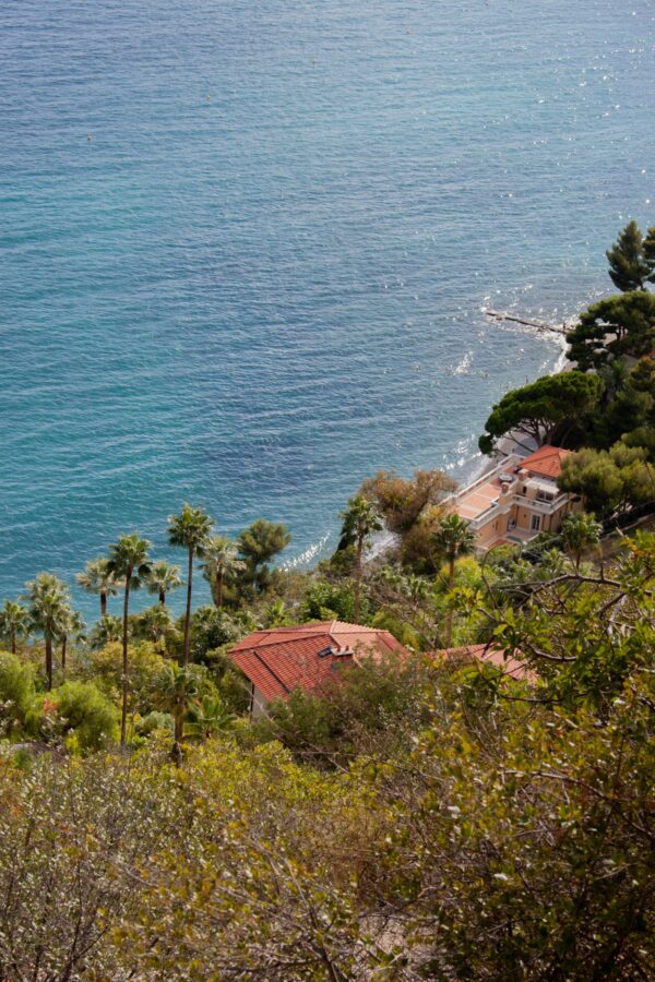 Villa mediterránea con vistas al mar entre vegetación de pinos